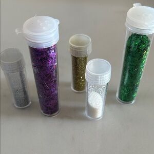 Assortment of used glitter in plastic containers